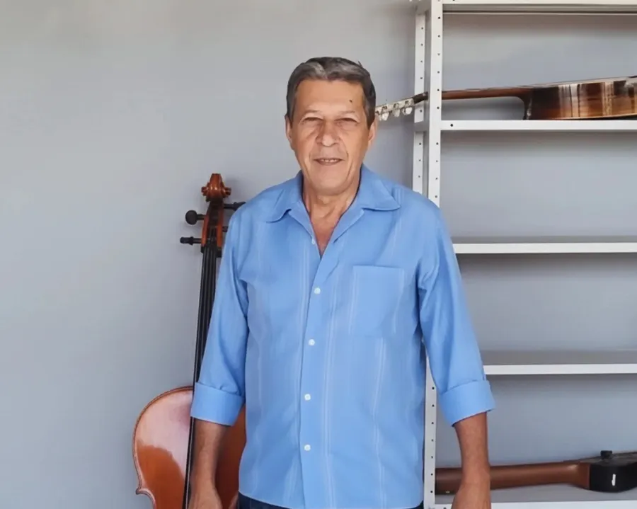 Deusdete Guimarães, presidente e fundador, ao lado de um violoncelo