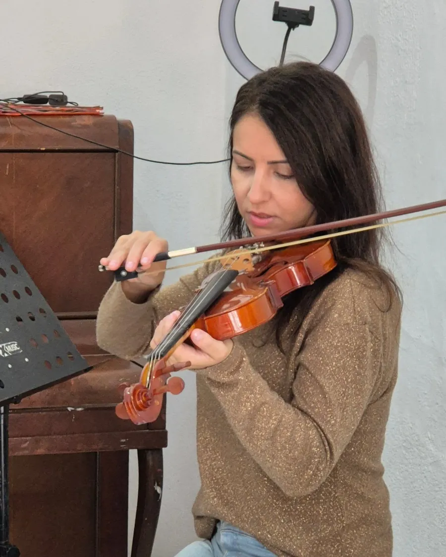 Violinista de suéter marrom lendo a partitura